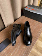 Prada unisex black leather loafers, one pair showing front and side profiles