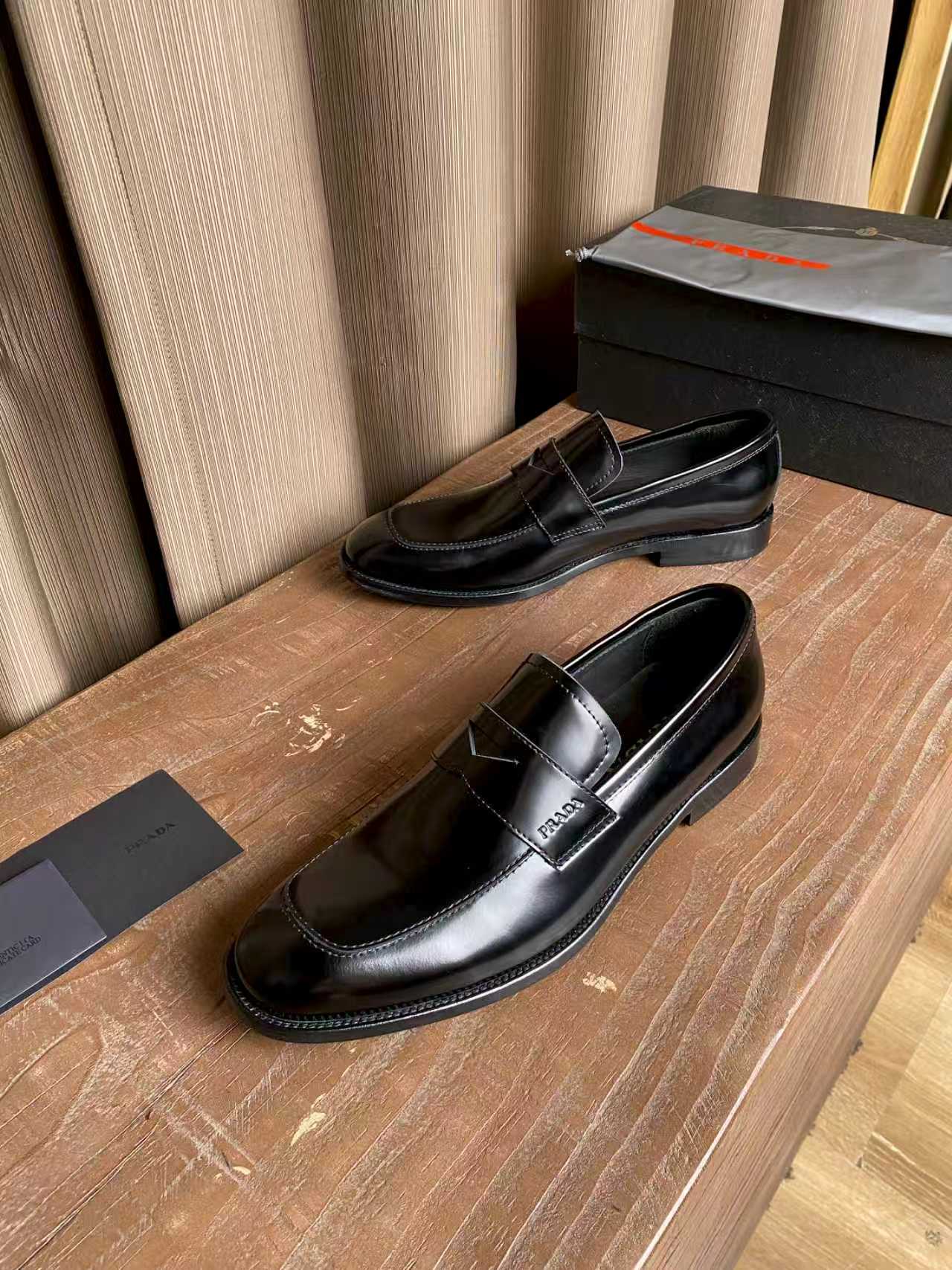 Prada unisex black leather loafers, top view showing stitched vamp and low heel