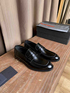 Prada unisex black leather loafers, classic slip-on style with decorative stitching
