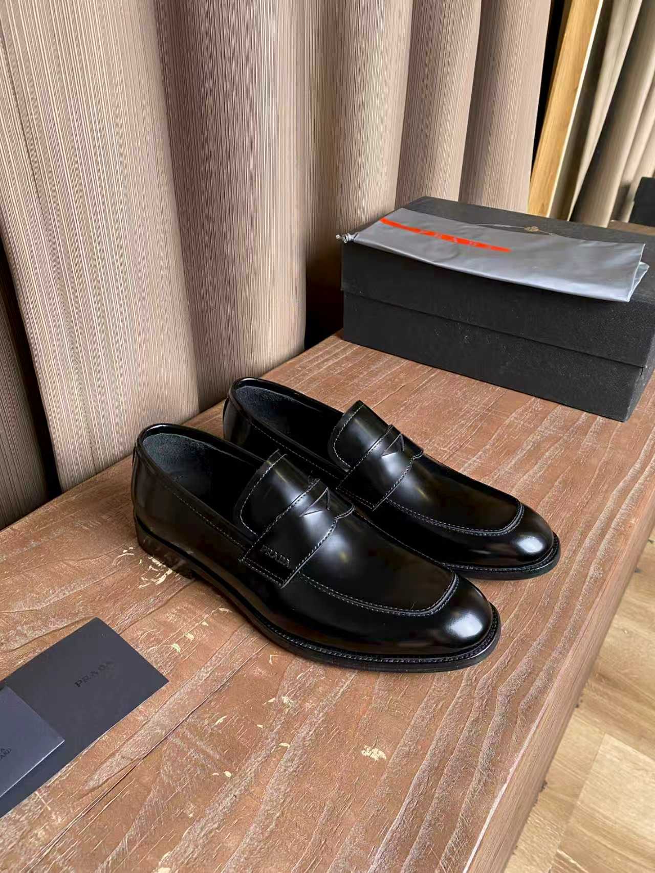 Prada unisex black leather loafers, classic slip-on style with decorative stitching