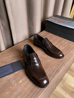 Brown patent leather slip-on loafers with apron stitching and dark rubber sole
