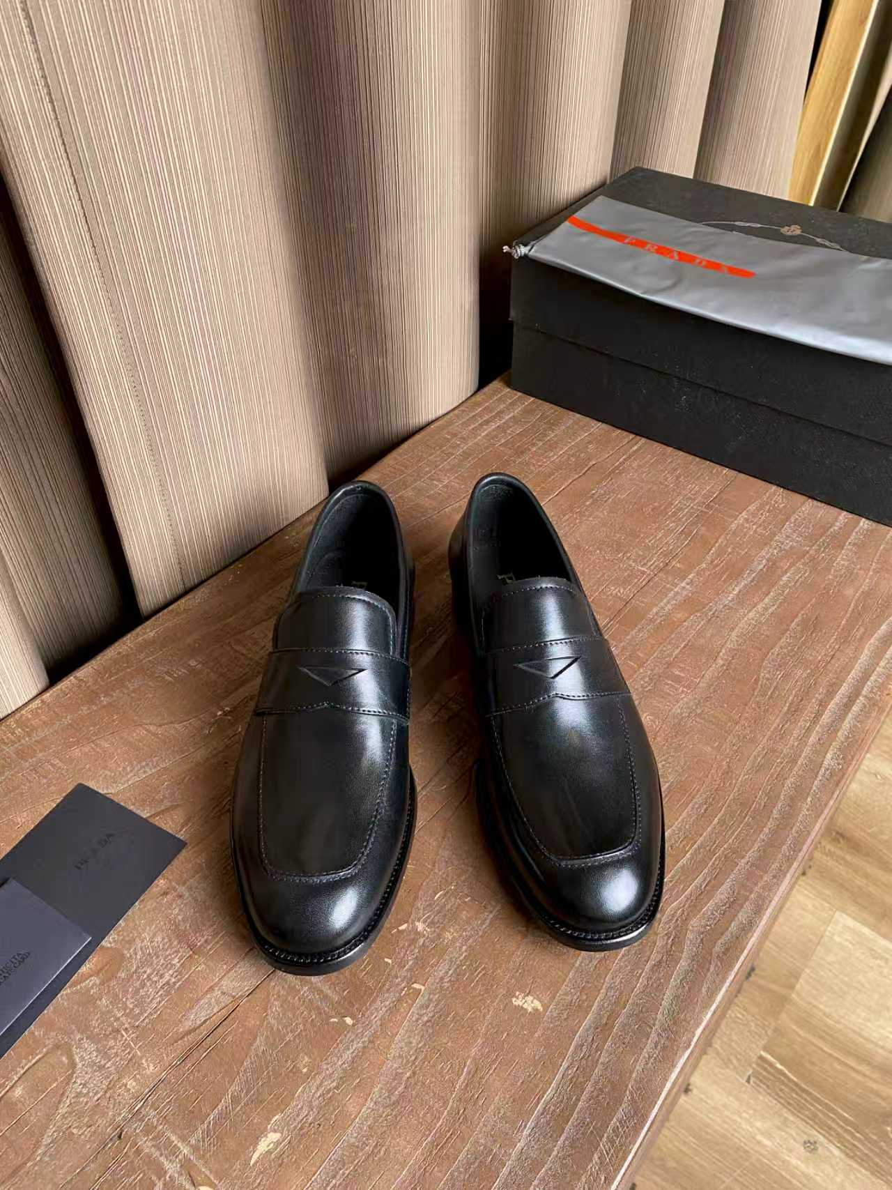 Prada unisex black leather penny loafers, stitched rounded toe and low heel