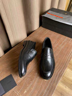 Prada unisex black leather loafers, rear view with stacked heel and seam lines