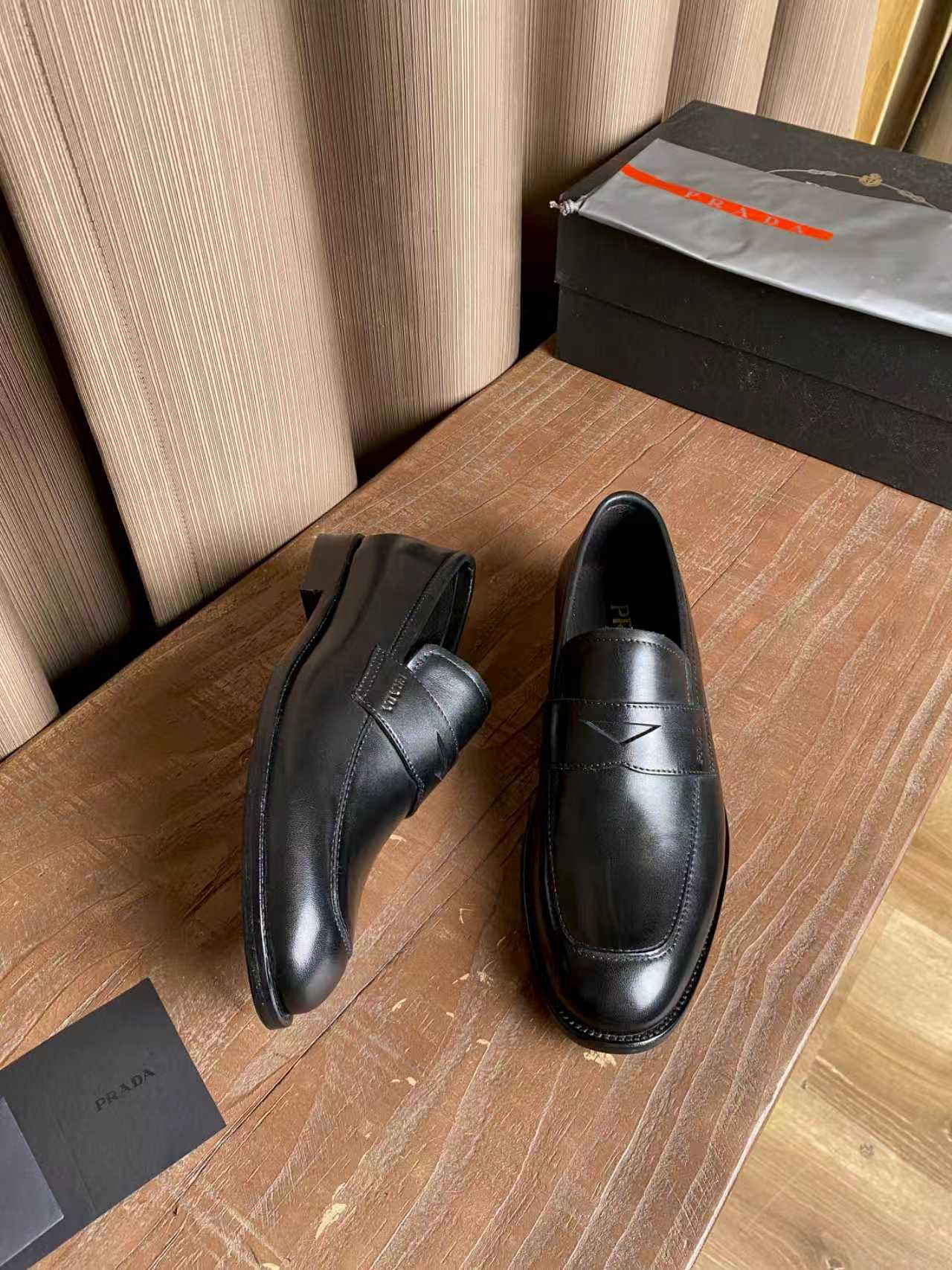 Prada unisex black leather loafers, rear view with stacked heel and seam lines