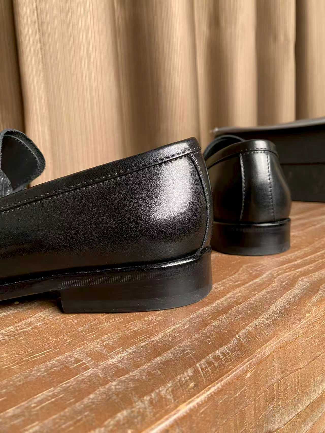 Prada unisex black leather loafers, smooth toe and back heel close-up