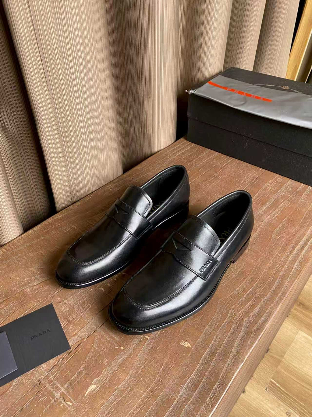 Prada unisex black leather loafers with decorative strap on the vamp