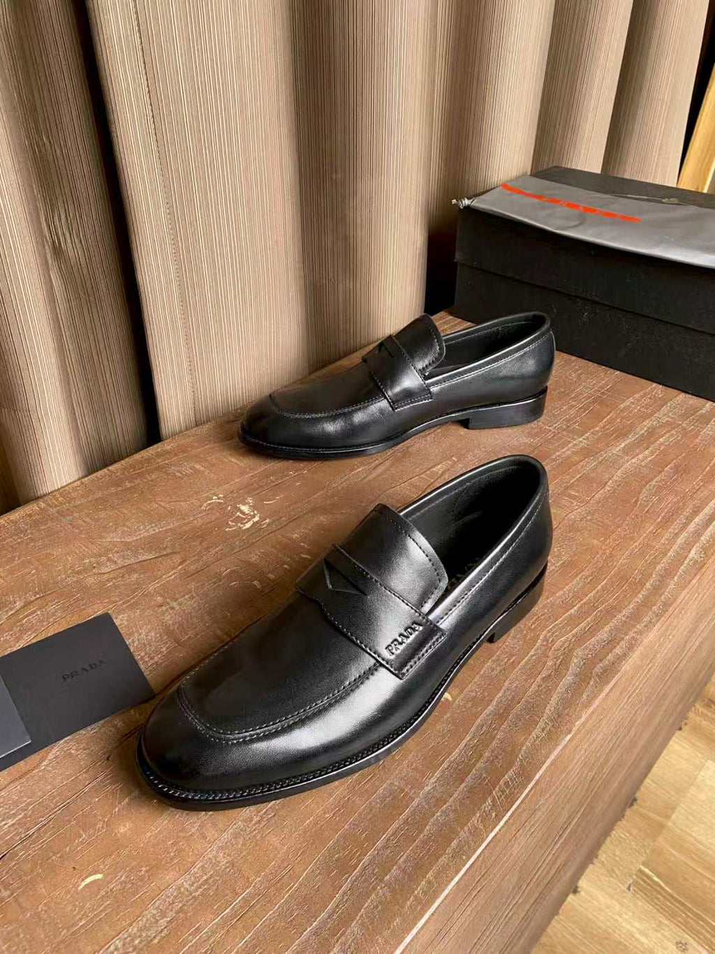 Prada unisex black leather loafers, side view with strap detail and low heel