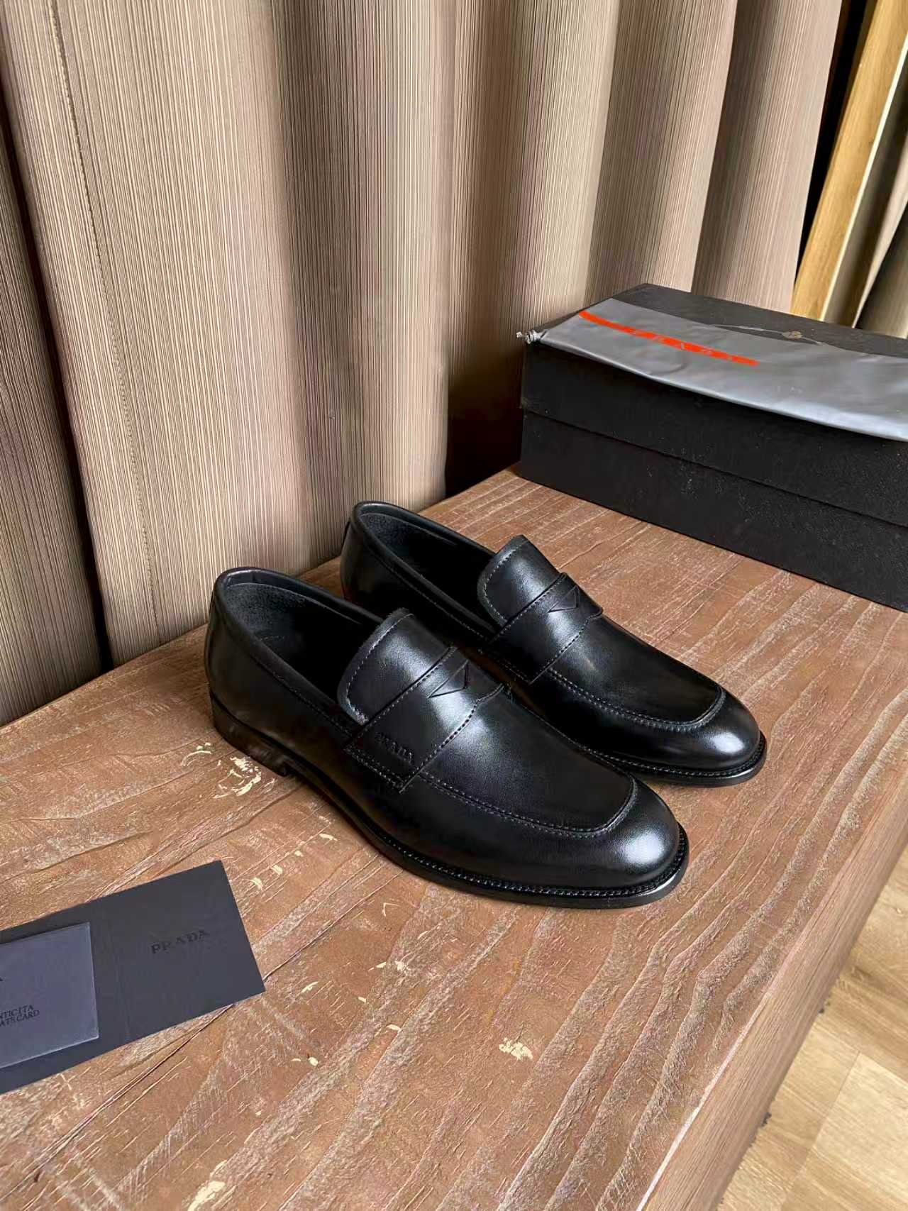 Prada unisex black leather loafers, moc-toe stitching and slip-on style