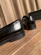 Prada unisex black leather loafers, close-up of low heel and side seam stitching