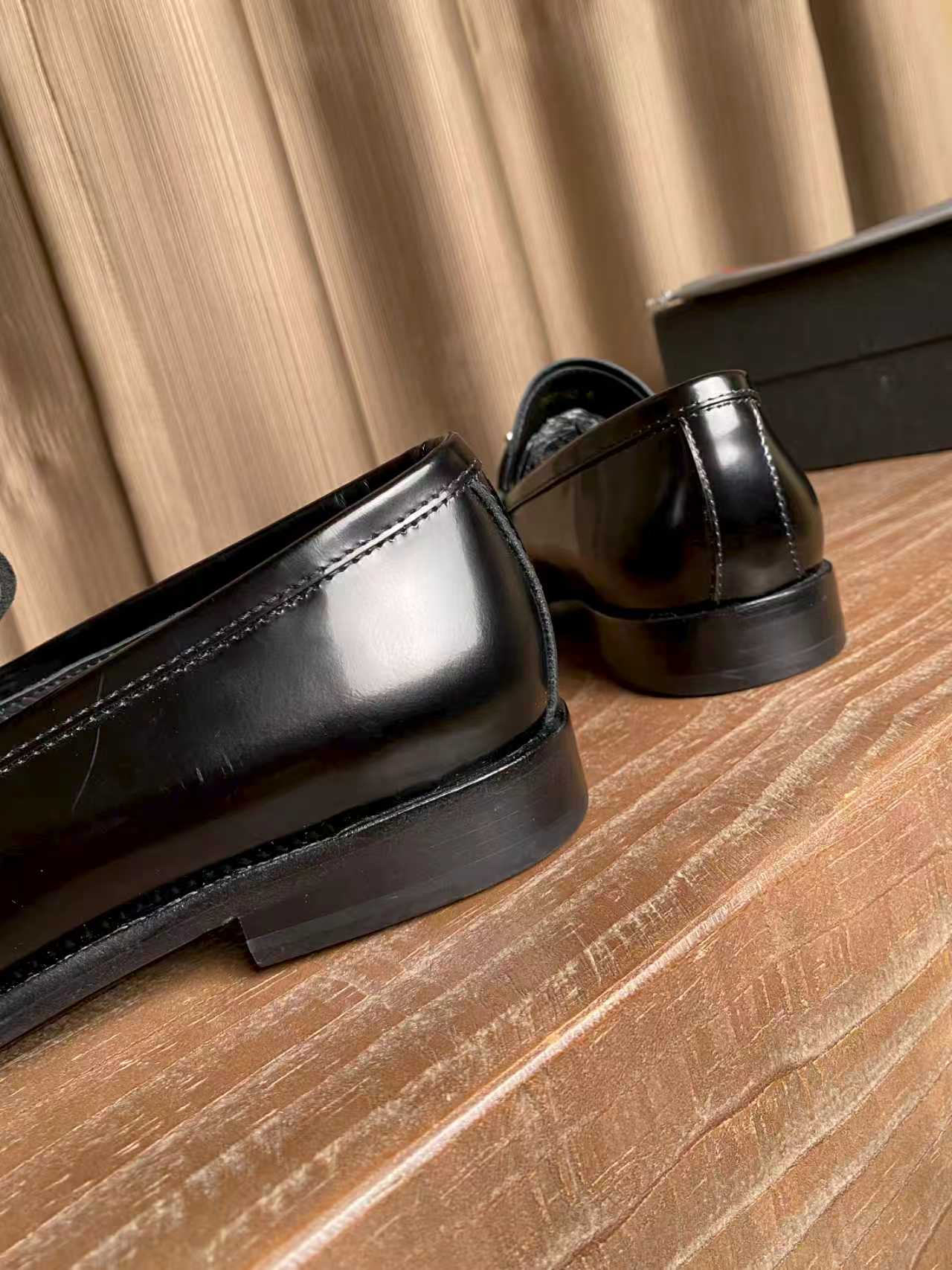 Prada unisex black leather loafers, close-up of low heel and side seam stitching
