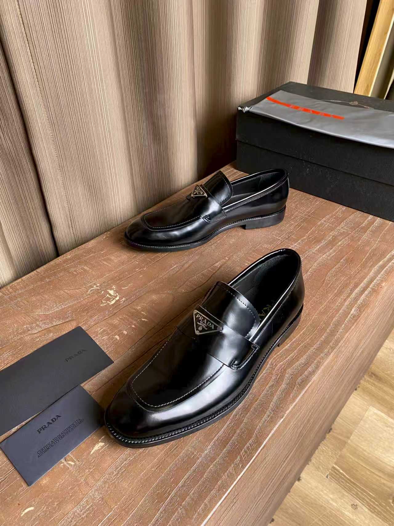 Prada unisex black leather loafers, heel and side profile with logo badge