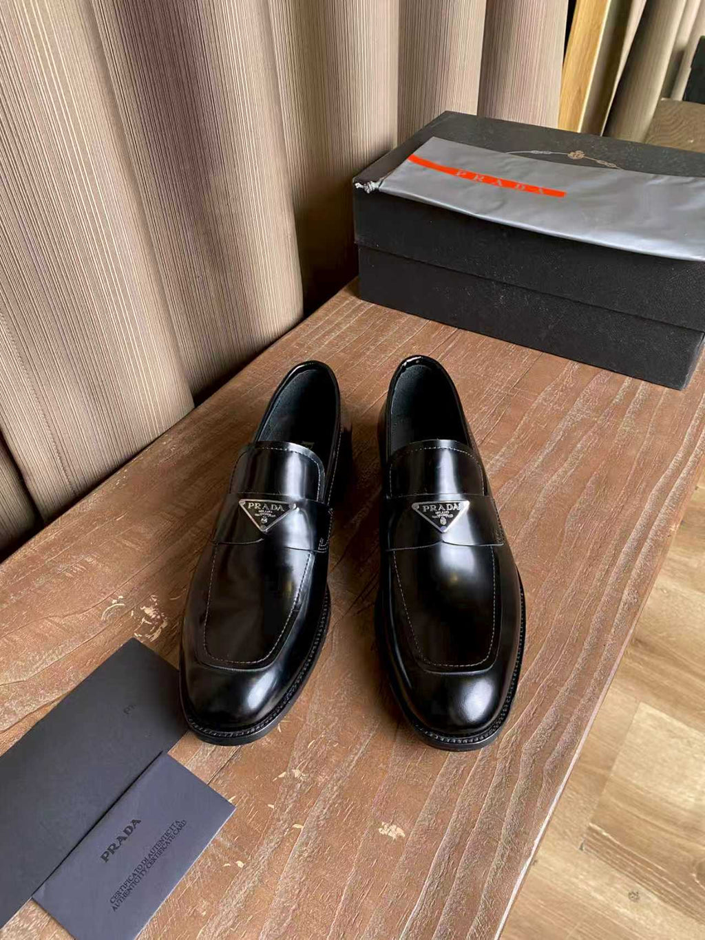 Prada unisex black leather loafers, slip-on with stitched moc toe and logo badge
