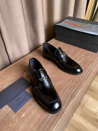 Prada unisex black leather loafers pair, slip-on style with stitched moc toe