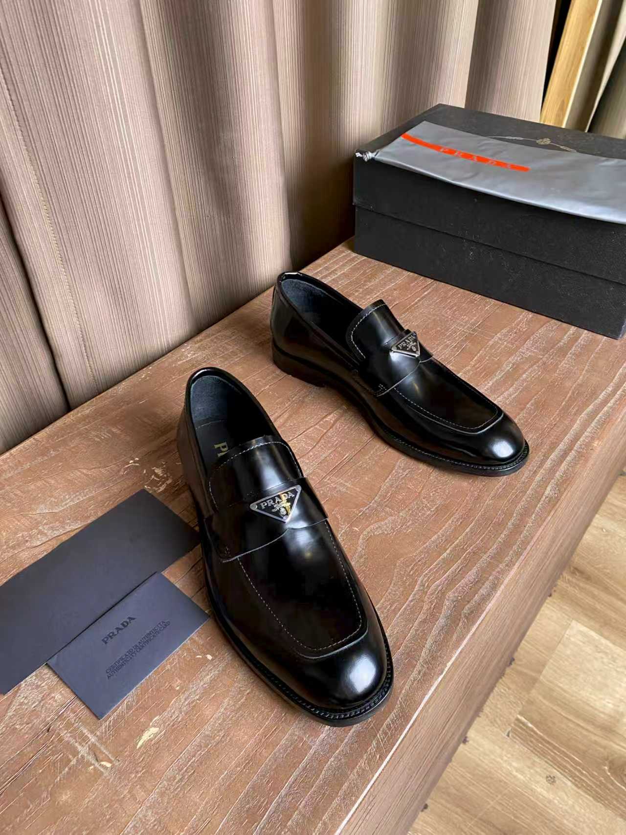 Prada unisex black leather loafers pair, slip-on style with stitched moc toe