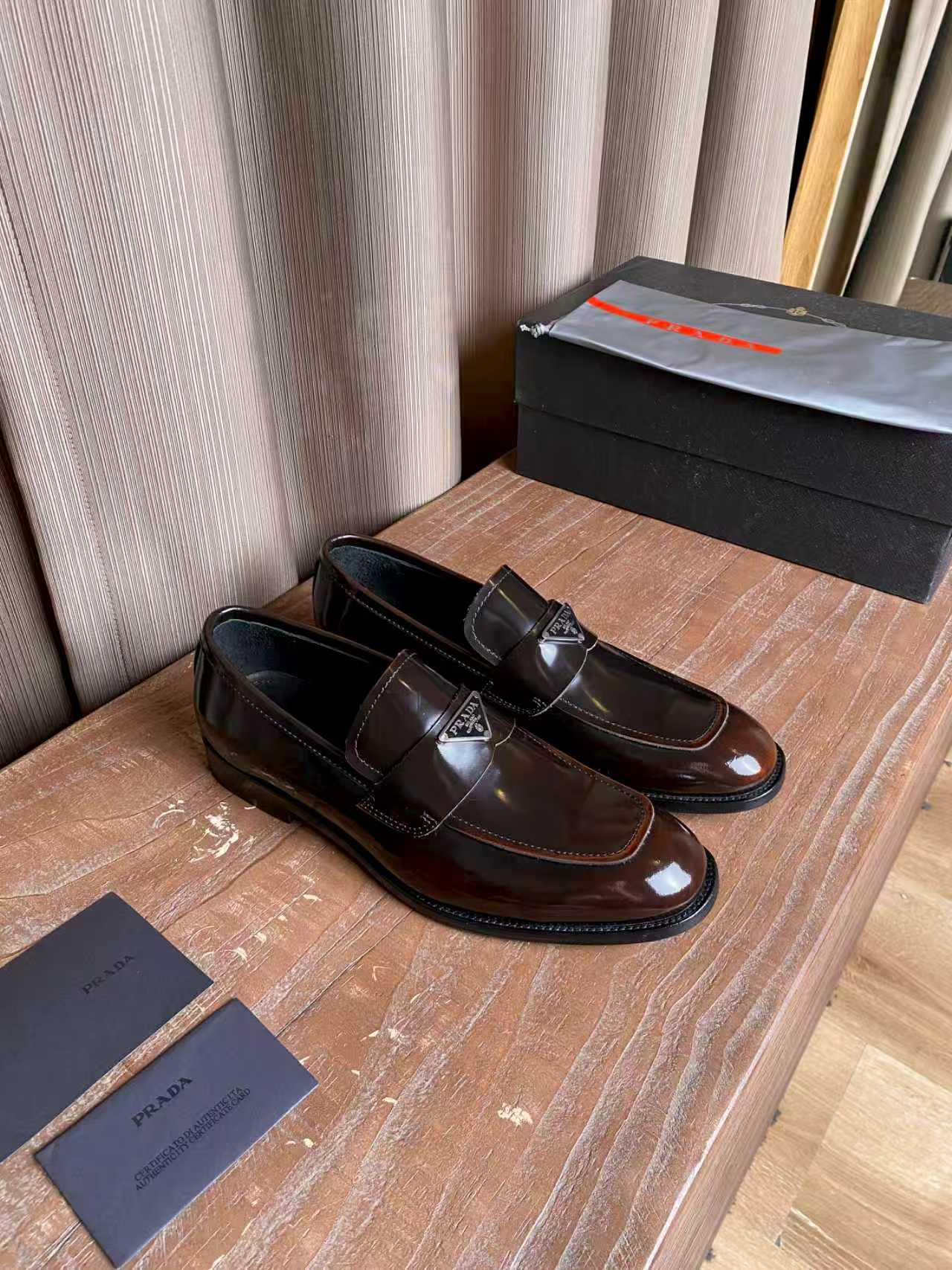 Prada unisex leather loafers, dark brown slip-on style with metal logo detail
