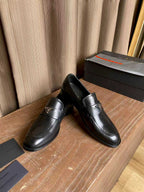 Prada black leather loafers, front view pair with strap and low heel