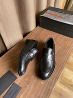 Prada black leather loafers, front view with logo accent on strap