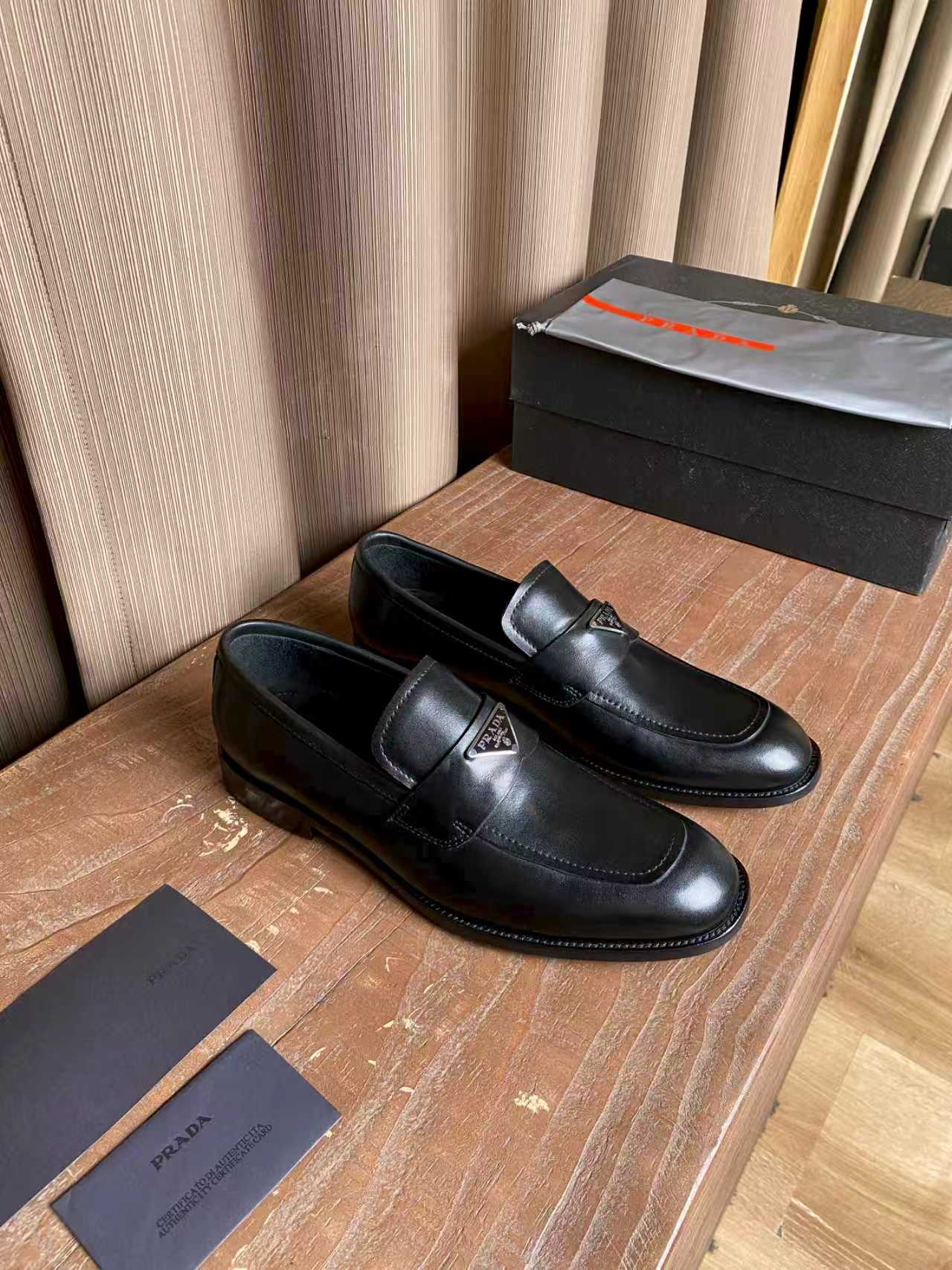 Prada black leather loafers, side view with strap and stitched trim
