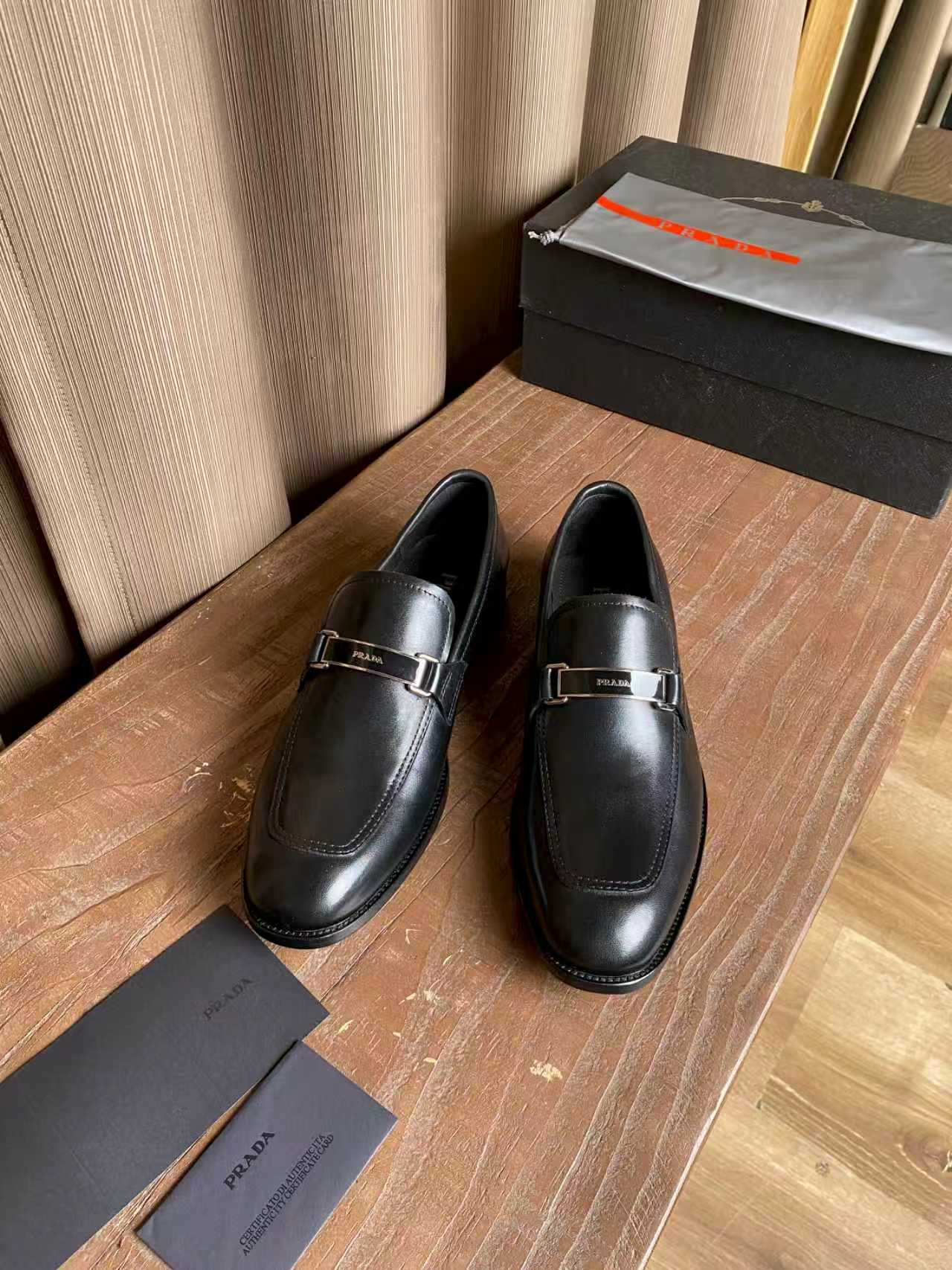 Prada unisex leather loafers in dark black, with metal buckle detail
