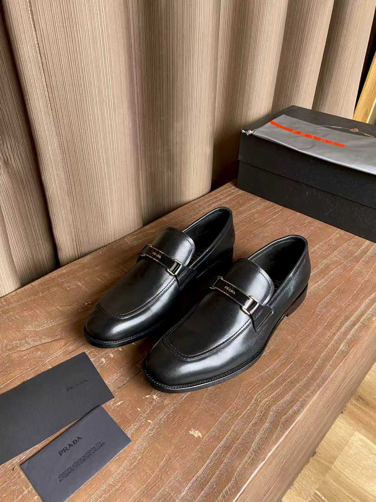 Prada unisex leather loafers, dark black slip-on design with buckle bar