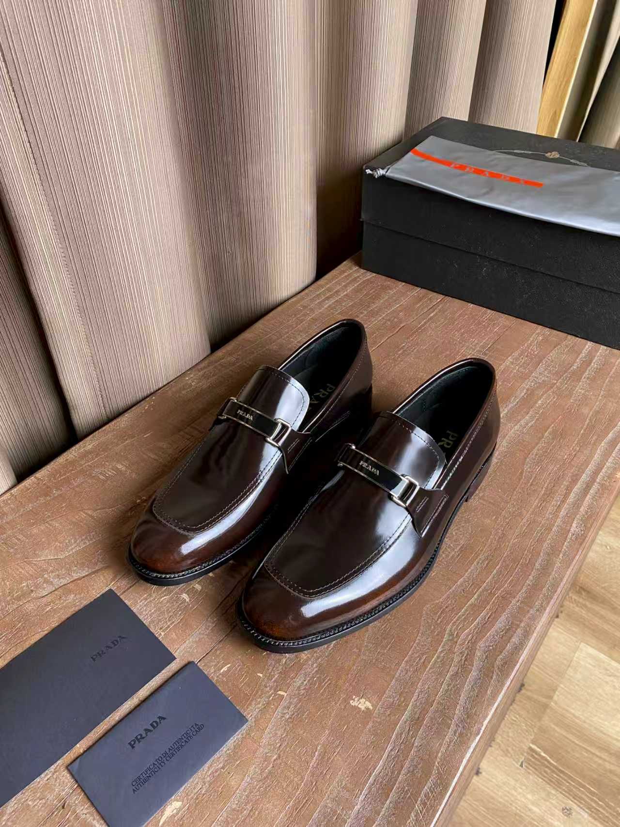 Prada unisex leather loafers, dark brown gloss with silver buckle strap, paired view