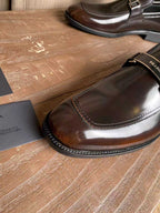 Prada leather loafer toe cap close-up, dark brown gloss with contrast stitching