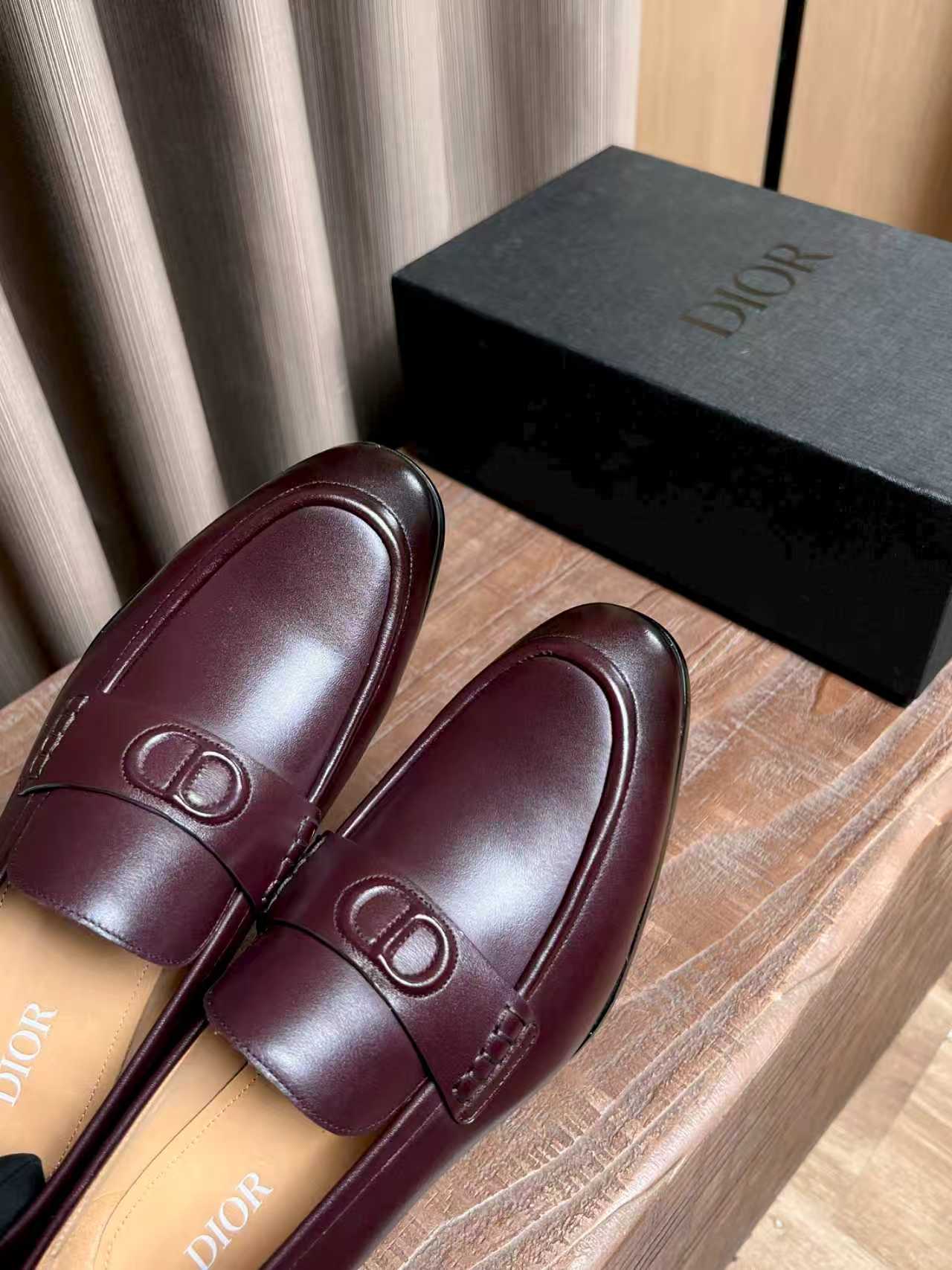 Close-up of burgundy leather loafers with D logo detail at vamp