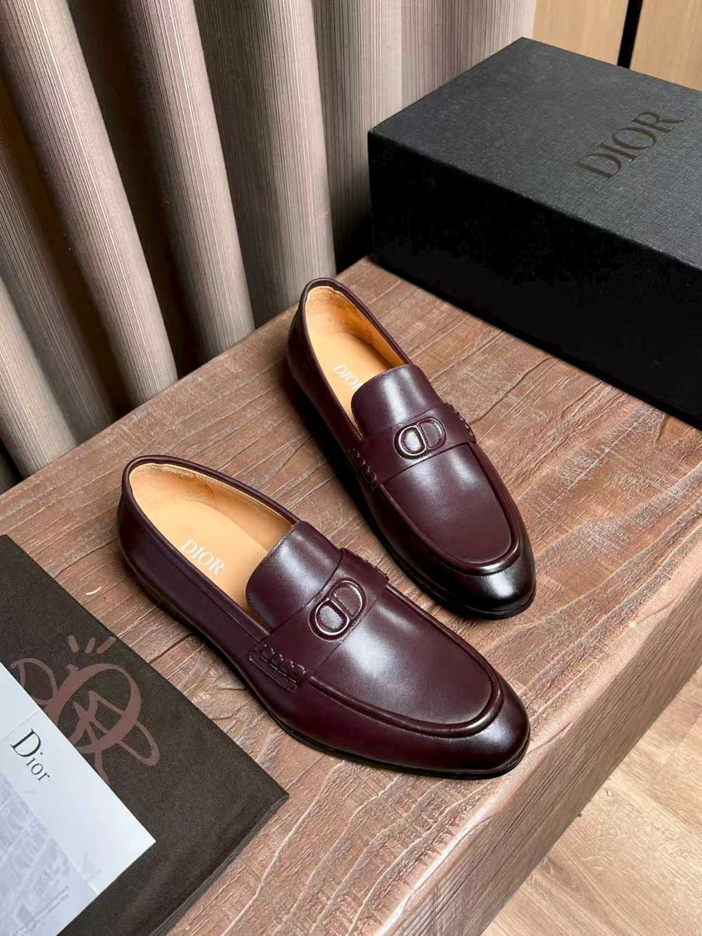Pair of burgundy leather loafers with front D-shaped logo detail