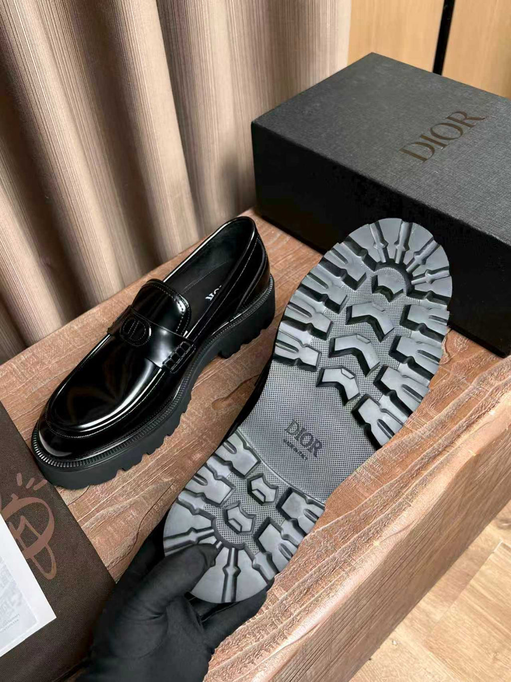 Black patent leather loafer with visible outsole tread and Dior branding on sole