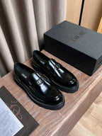 Black patent leather loafers with silver buckle ornament and low platform sole