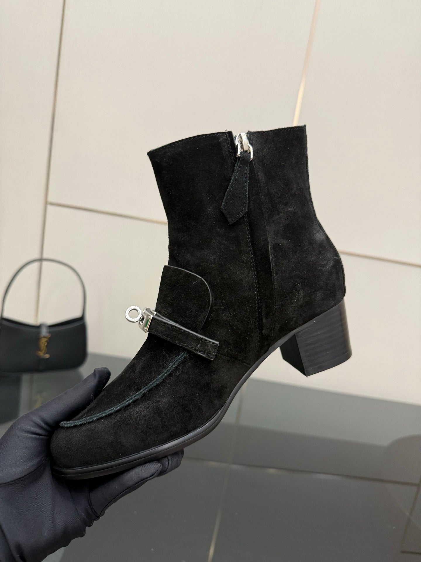 Black women’s ankle boots with side zipper and buckled strap detail