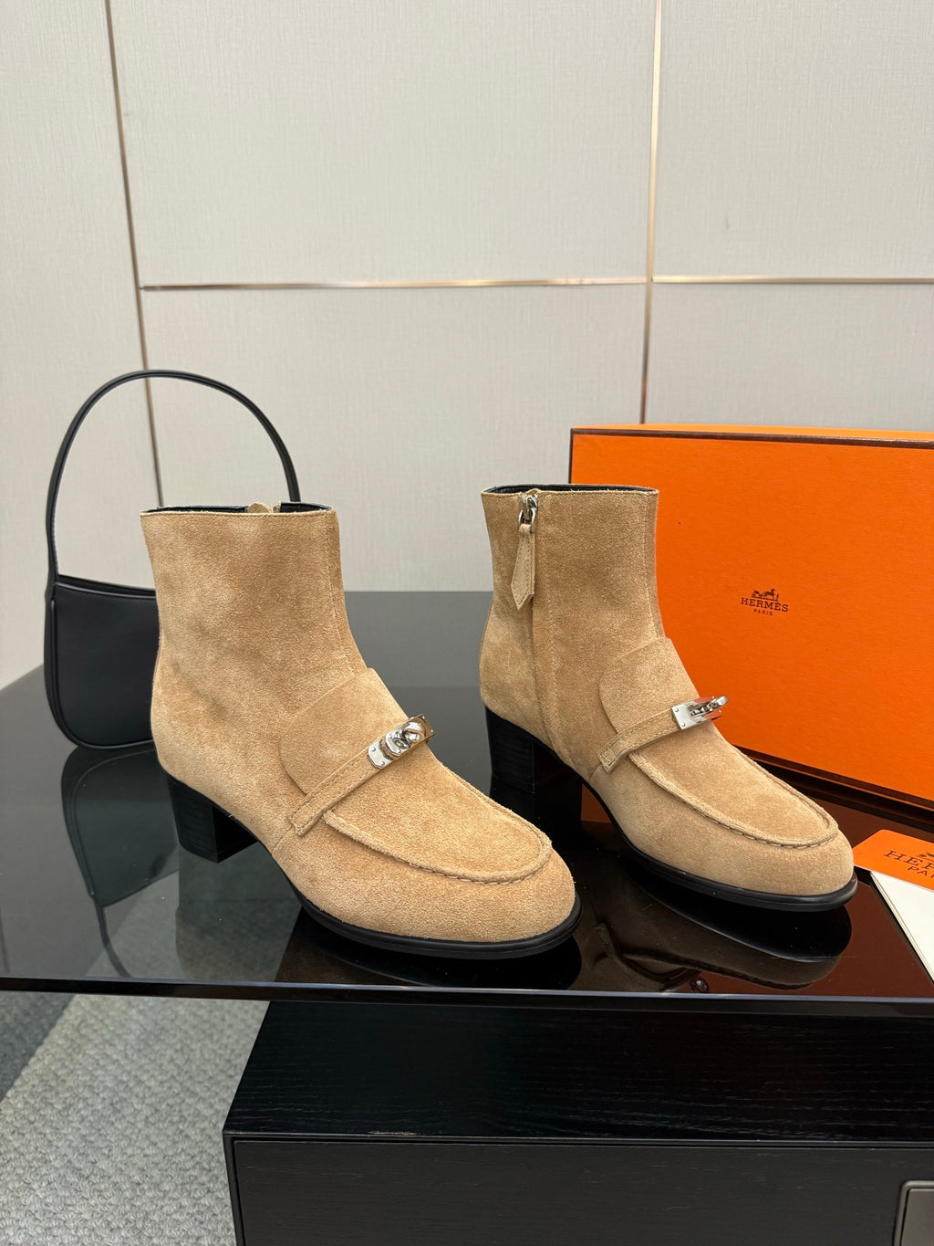Pair of tan suede ankle boots with decorative silver buckles and low block heel.