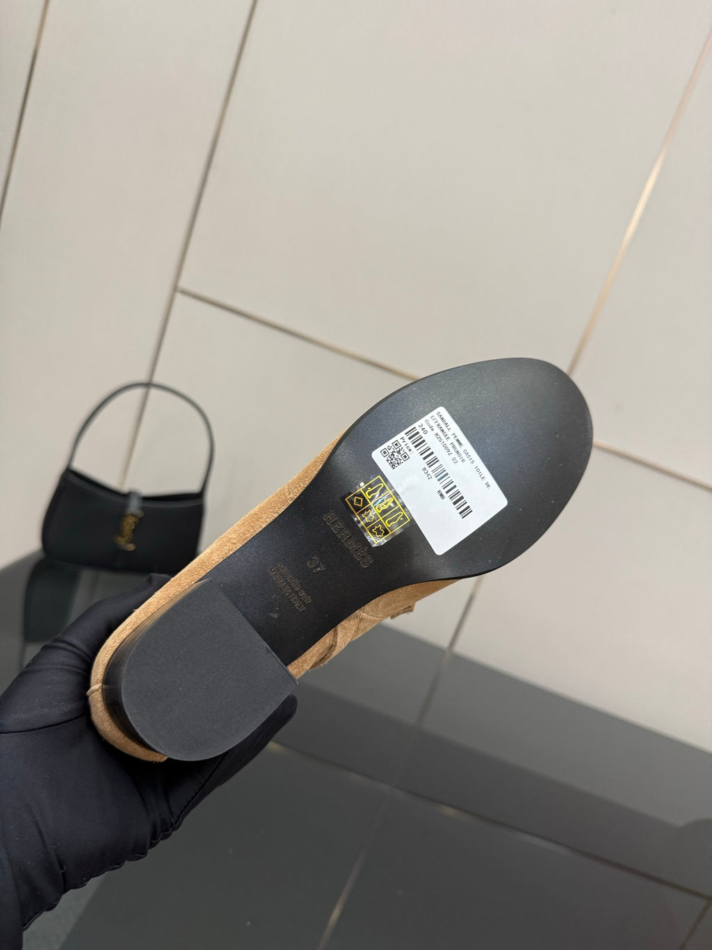 Tan ankle boot sole and heel with embossed logo and label on underside.
