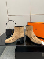 Tan suede ankle boots with cuff strap detail, silver hardware, and block heel.