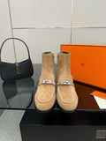 Women’s tan suede ankle boots with block heels and silver side buckles.