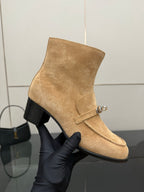 Tan suede ankle boot with side zipper pull and silver buckle strap on block heel.