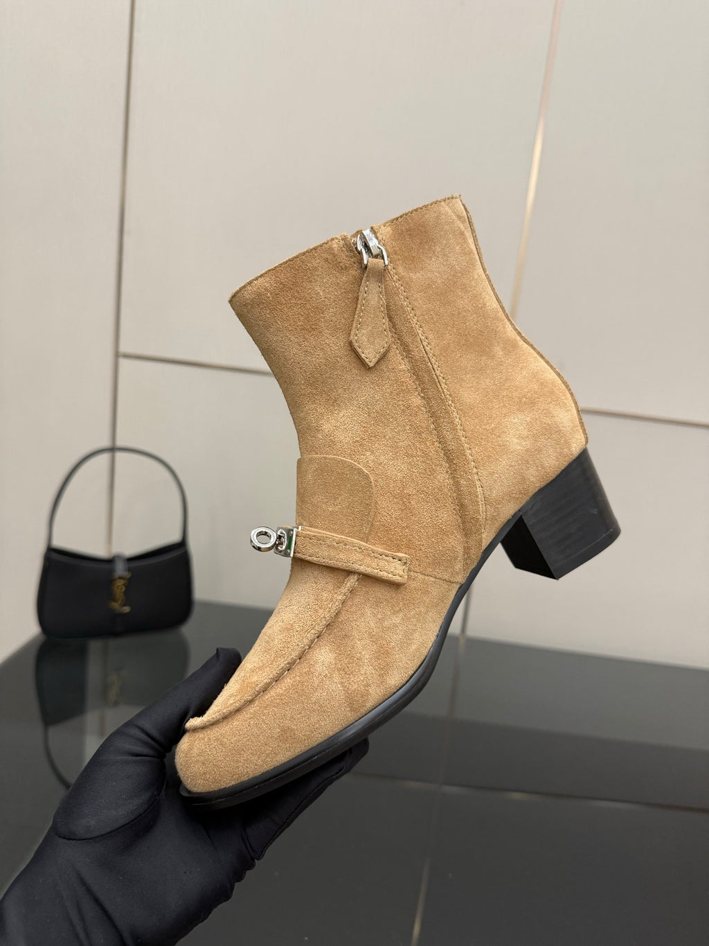 Tan suede ankle boot with front strap, silver buckle, and chunky block heel.