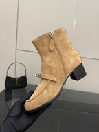 Tan suede ankle boot with front strap, silver buckle, and chunky block heel.
