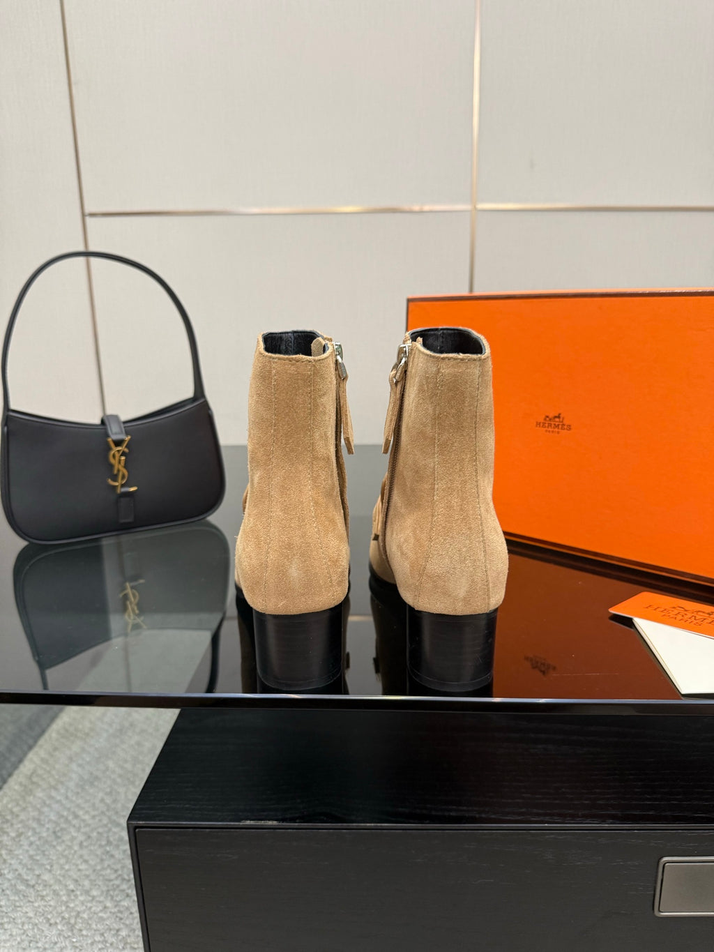 Tan suede ankle boots with silver buckles and block heels standing upright.