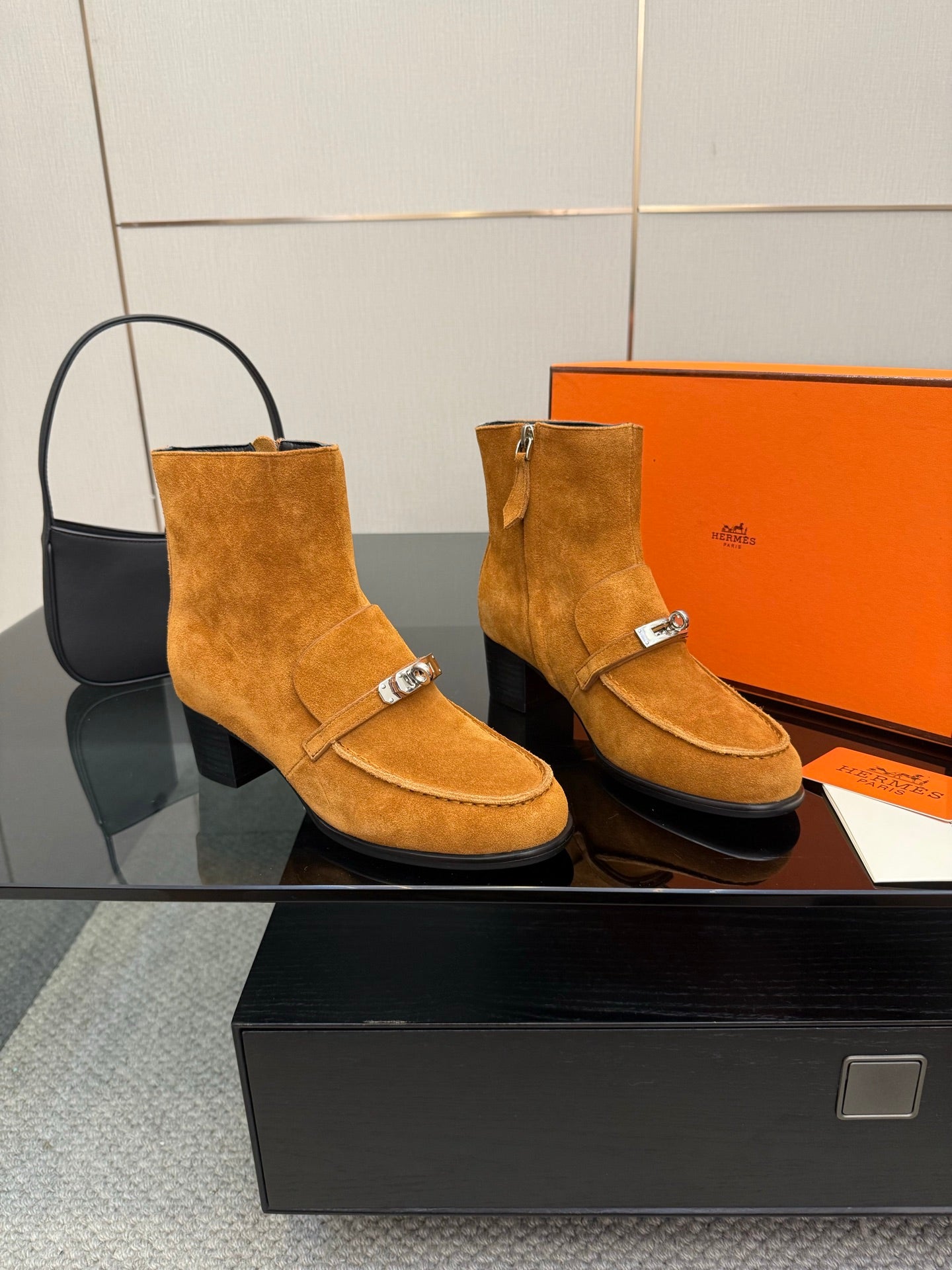 Tan suede ankle boots with buckle straps and block heels, front view on display.