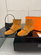 Tan suede ankle boots with side buckle strap and block heel, shown from the side.