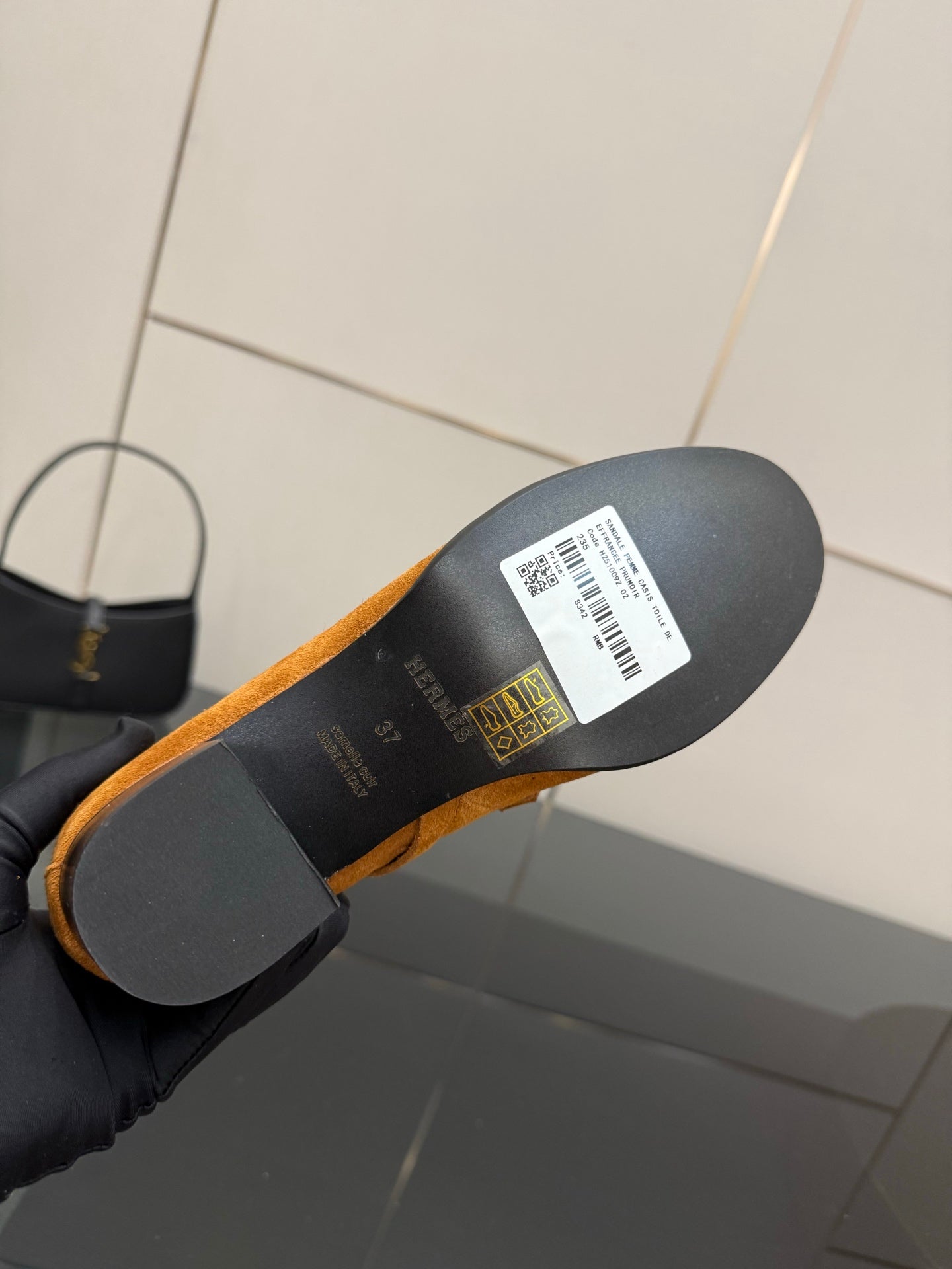 Tan suede ankle boot outsole with label and barcode, showing the bottom view.