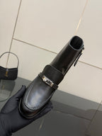Hermes ladies black leather ankle boot held in hand, side zipper detail