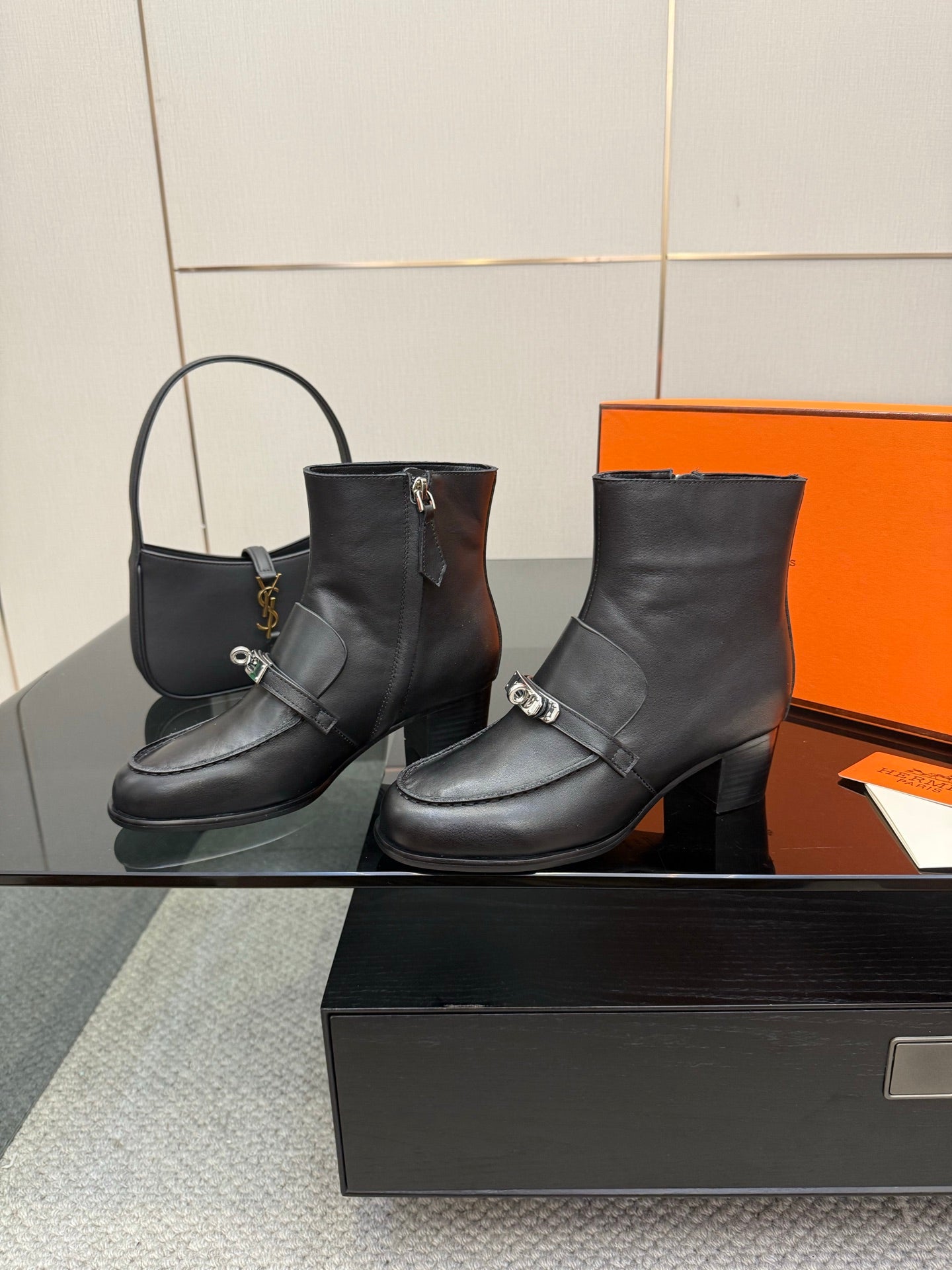 Hermes ladies black leather ankle boots with silver buckle strap, side view pair