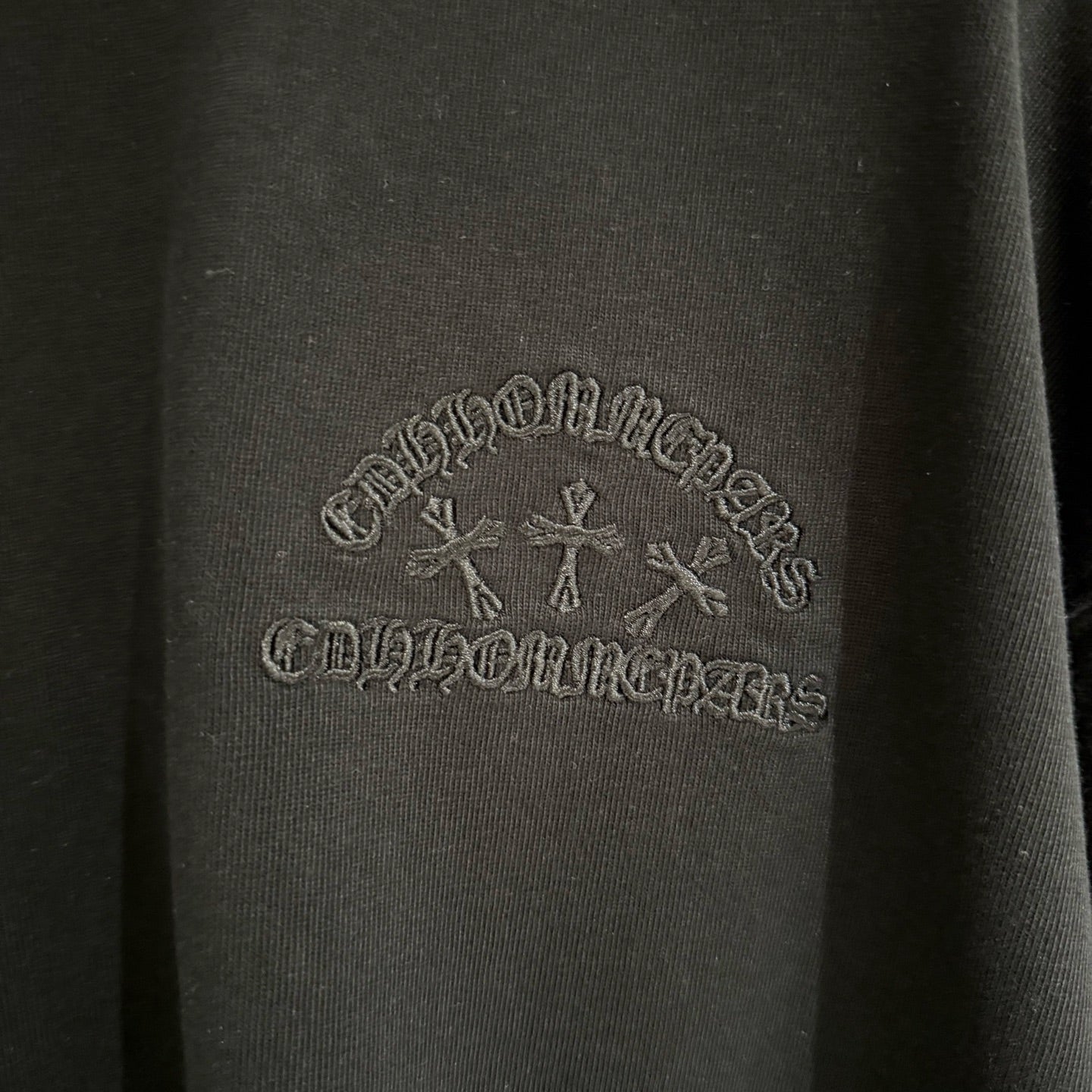 Black fabric with gray tone-on-tone logo embroidery across the chest