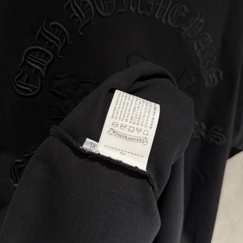 Black sweatshirt sleeve with white care label and stitched seam detail
