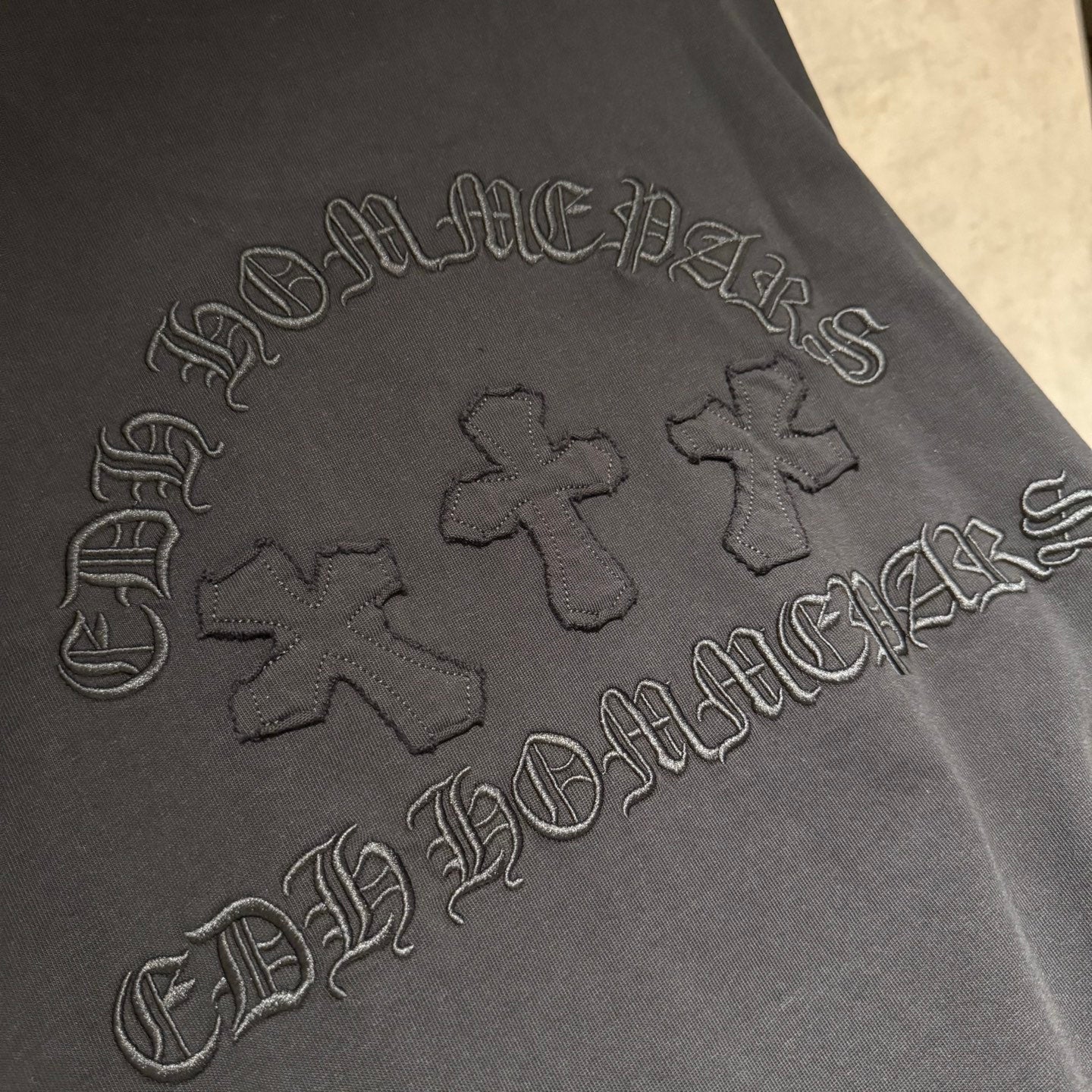 Black sweatshirt sleeve with graphic logo embroidery