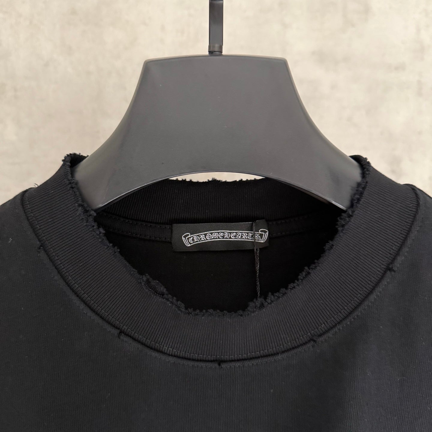 Black crewneck sweatshirt neckline with ribbed collar and inner brand label