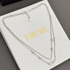 Silver-tone necklace on white box with DIOR logo and heart charm drops