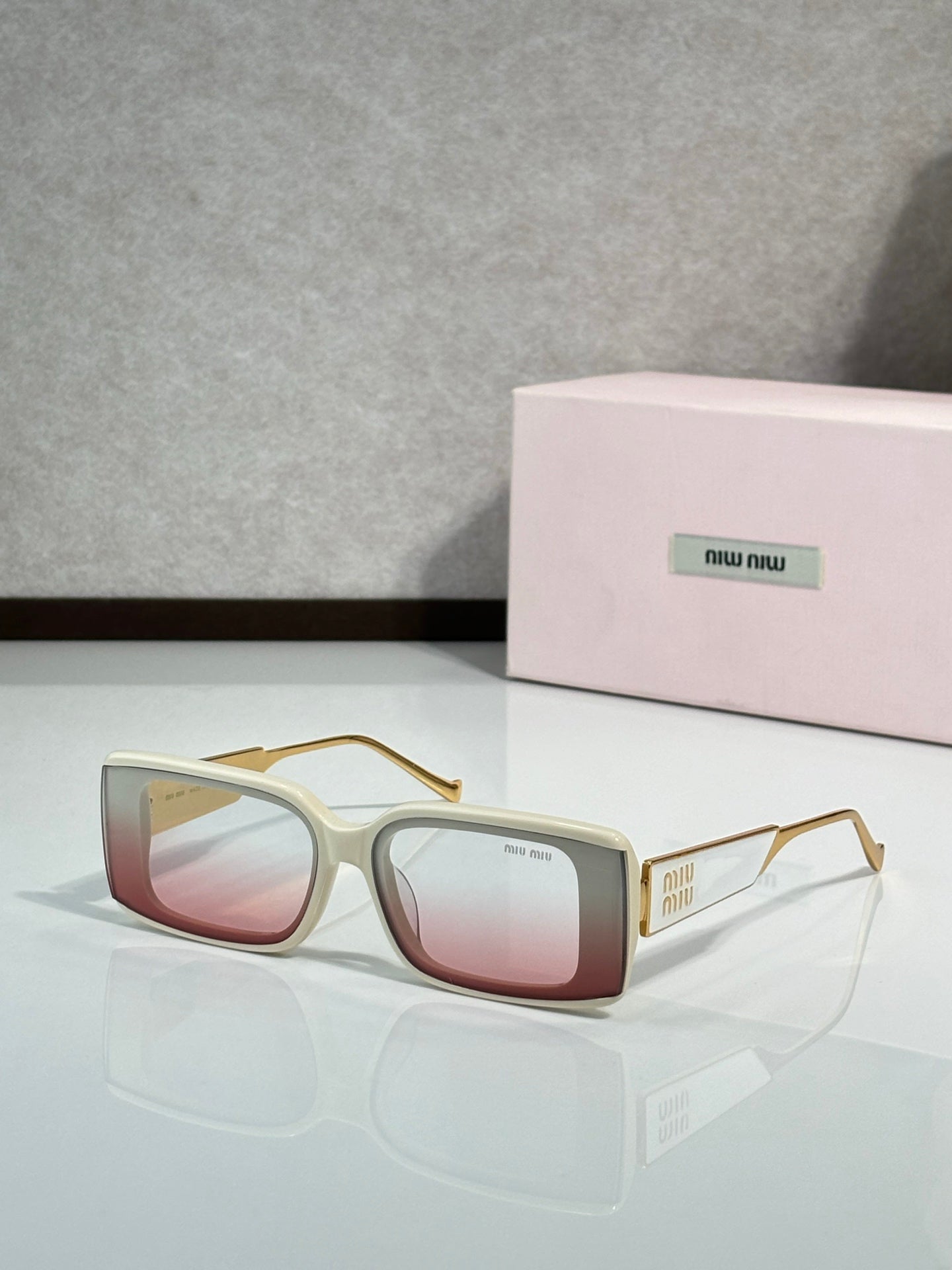 MiuMiu sunglasses with cream square frames and pink-tinted lenses